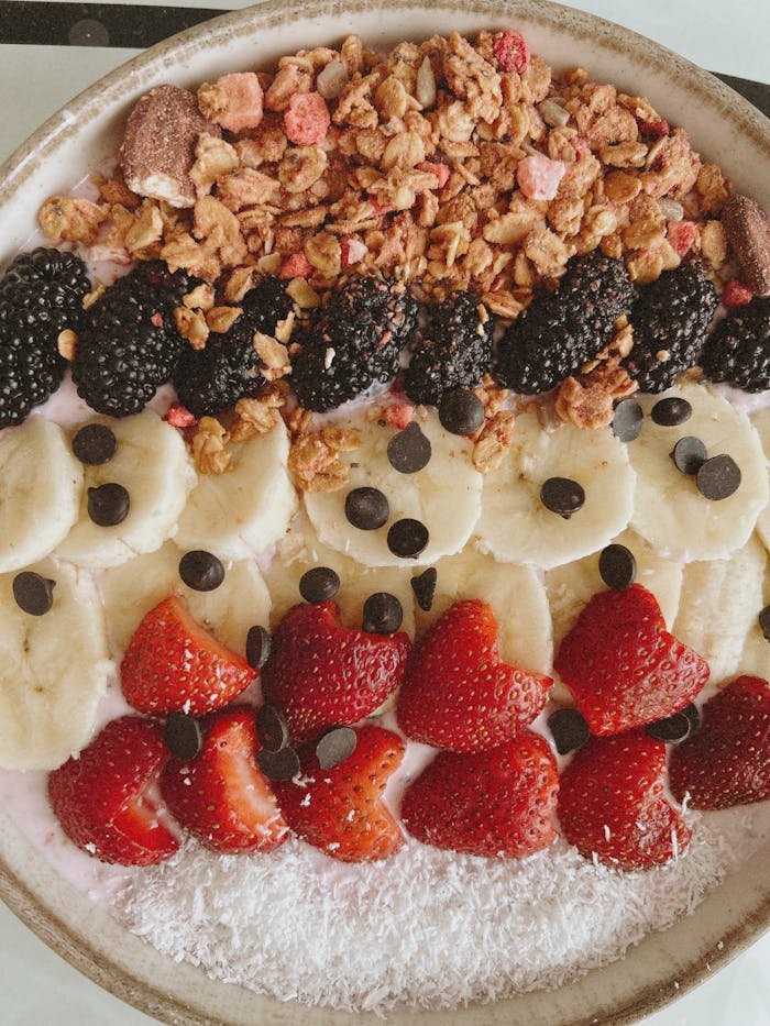 Delicious breakfast bowl with fresh fruits, granola, and chocolate chips.
